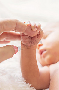 刚出生的婴儿握着妈妈的手。