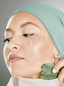 gua摄影照片_女人在脸上使用面部石头。
