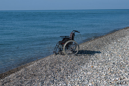 岩石海岸上的空轮椅。