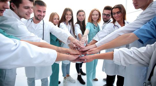 合作的手势摄影照片_一群多元化的医疗专业人员表现出他们的团结