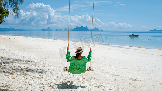 泰国普吉岛附近热带岛屿纳卡岛海滩上的女人，海滩秋千上的女人