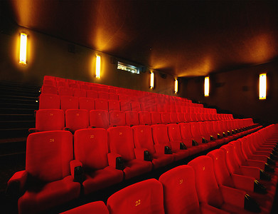 晚上，在电影院或电影院室内房间前，空荡荡的电影院或电影院，有一排红色座椅。