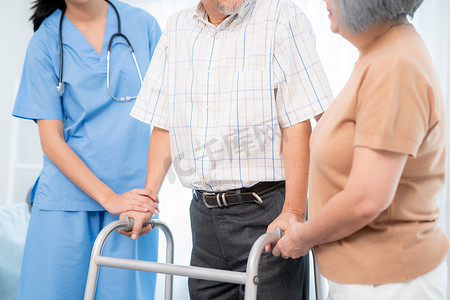 在妻子和看护人的帮助下，心满意足的老人正在折叠助行器。