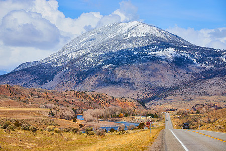 通往山脉的公路摄影照片_白雪覆盖的山脉压倒了通往他们的小路