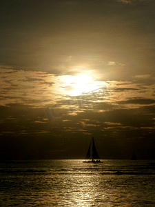 日落透过云层，光线反射在海洋上