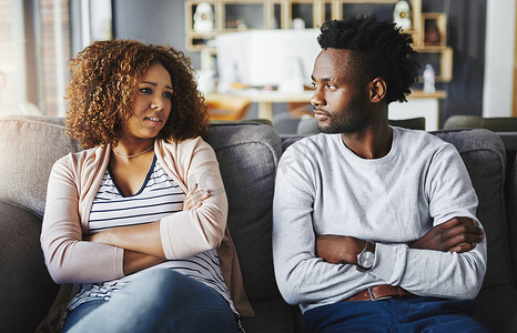 不幸福的夫妻一起坐在家里的沙发上谈论分手或关系中的问题。