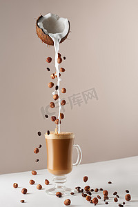 玛奇朵摄影照片_玻璃杯配卡布奇诺和芬芳的泡沫、椰奶、榛子、种植的咖啡豆。