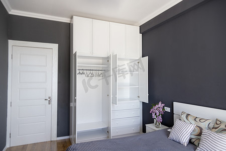 卧室内部配有空白色衣柜和灰色墙壁。