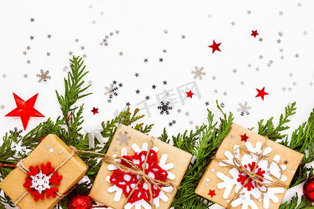 圣诞节和新年背景与崖柏树枝、装饰品和用雪花牛皮纸包裹的礼物。