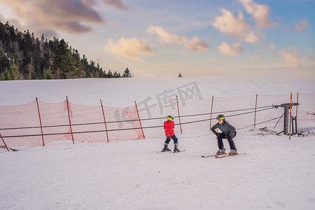 男孩在冬天在斜坡上学习滑雪、训练和听他的滑雪教练