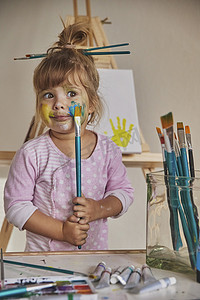 玩颜料的孩子摄影照片_迷人的孩子用颜料画画和染色一切