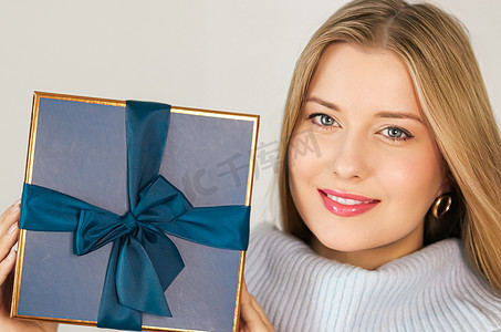 寒假、礼物和圣诞快乐的概念，快乐的女人微笑着拿着包装好的礼盒