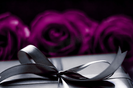 圣诞节礼物棒摄影照片_豪华假日银礼盒和紫色玫瑰作为圣诞节、情人节或生日礼物