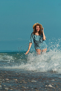 夏天海边的一个美丽女孩高兴地在水上玩耍，情绪激动