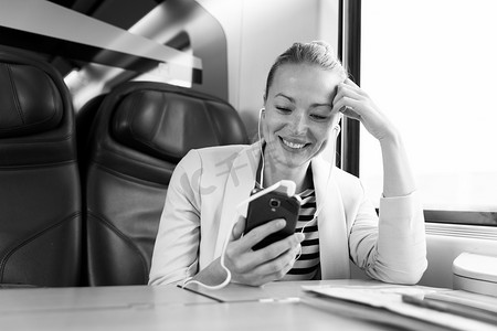 女商人在乘火车旅行时用手机交流。