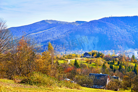 蓝色薄雾中山谷和山脉中秋季小村庄的鸟瞰图