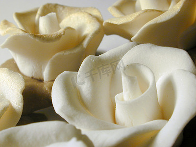 撒上金粉的白色糖霜玫瑰的特写