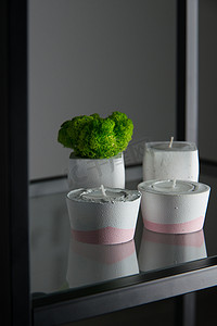 白色和粉色混凝土烛台中的蜡烛和苔藓