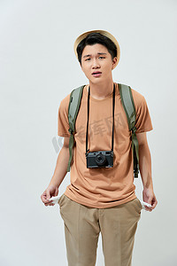 丢帽子摄影照片_年轻的亚洲游客丢了钱，站在白人背景下感到失望。