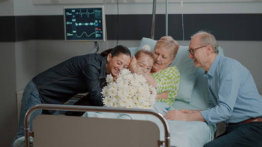 送母亲鲜花摄影照片_访客给卧病在床的妇女送花的特写