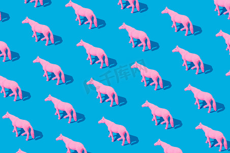 蓝色背景上孤立的粉色橡胶马拼贴画。