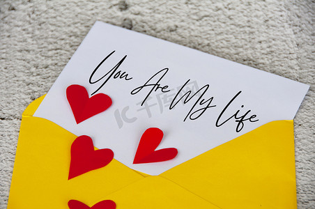 你是我在记事本上的生活文字，黄色信封，周围环绕着心形。
