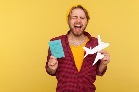 兴奋的嬉皮士拿着护照文件和飞机模型，欢欣鼓舞的旅行。