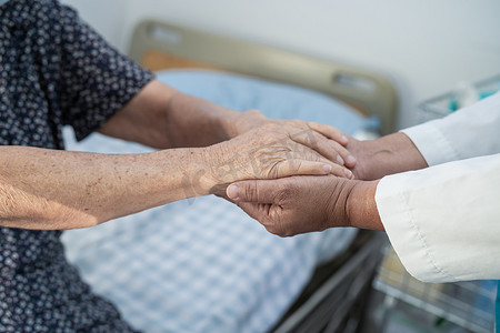 在护理医院病房牵手亚洲老年或老年老妇患者的爱、关怀、鼓励和同理心，健康强大的医疗理念