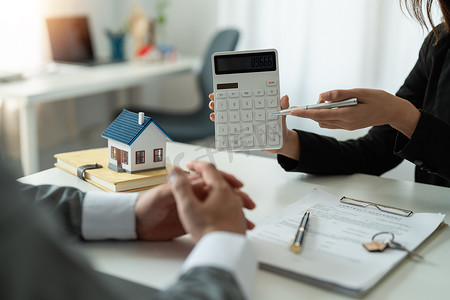 房地产经纪人展示金融利率住房贷款，以合法签署协议客户合同、房屋销售和家庭保险概念。