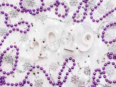 圣诞节和新年背景与 2019 年数字、紫罗兰色装饰和灯泡。