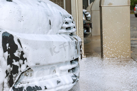 自助洗车时，将泡沫涂在机器上，将污垢洗掉。