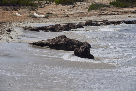 海浪冲击着海滩岸边的大岩石