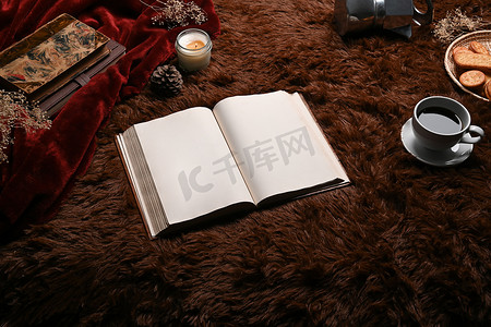 一本书和咖啡杯放在蓬松的地毯上。