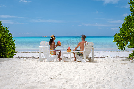 海滩上的男女情侣喝椰子饮料，普拉兰塞舌尔热带岛屿，海滩和棕榈树，安斯沃尔伯特塞舌尔海滩