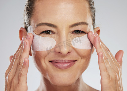 眼睛健康、护肤和成熟女性，在灰色工作室背景下使用面部皮肤科产品。