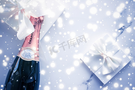 饮料瓶摄影照片_蓝色假日闪光、新年、圣诞节、情人节、冬季礼物和饮料品牌的奢侈品包装上的香槟瓶和礼盒
