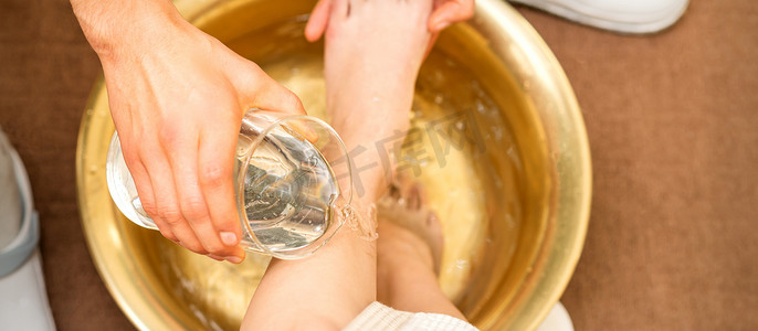 在美容 spa 沙龙的金碗里，按摩师手洗腿的顶部视图。