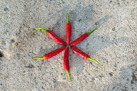 许多小红辣椒特写，躺在石头背景上。