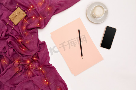 一杯咖啡，黑色智能，粉红色的纸，上面写着新年目标。