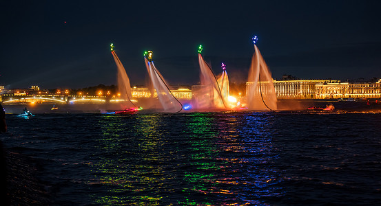 许多飞板手和穿着鲜艳的水上摩托艇运动员在圣彼得堡市中心的一个假期晚上表演他们的表演，进行水上活动