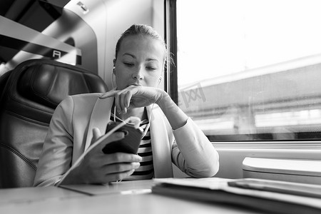 女商人在乘火车旅行时用手机交流。