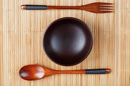 竹盘子摄影照片_竹背上的天然木盘、勺子和叉子。