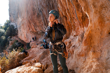 抱石摄影照片_女孩，攀岩者把头盔戴在头上。