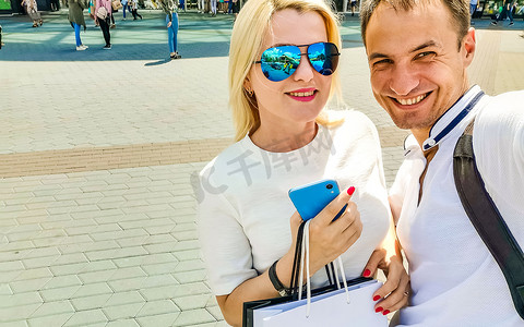 暑假、科技、爱情、关系和约会概念-微笑的情侣在城市里用智能手机自拍