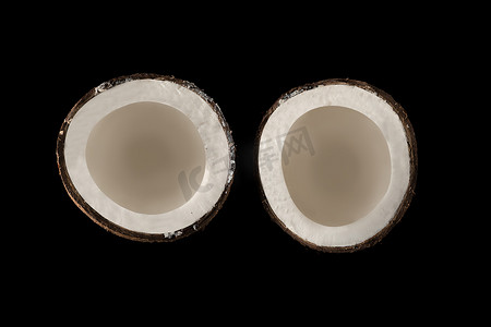 椰子分成两个相等的部分，从顶部看，在黑色背景上，孤立