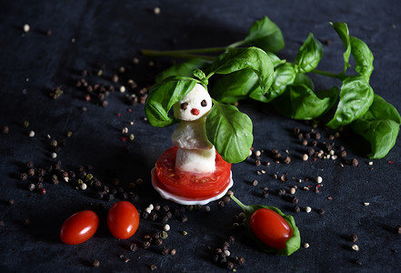 散射性摄影照片_一品红背景下的马苏里拉奶酪、西红柿创意雪人小食