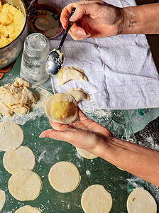 在乌克兰民族美食中，妇女用勺子用土豆雕刻饺子。