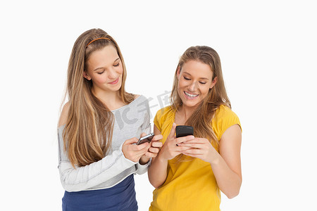 两名年轻女子用手机发短信