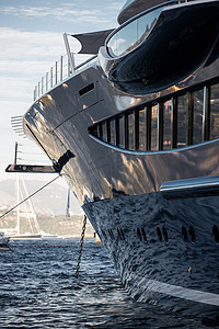 船在水中倒影摄影照片_停泊在巨大游艇光面的水面令人着迷的倒影，镀铬细节、链条和绳索沉入水中