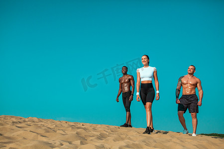 一群年轻的男女运动员，适合在天空背景下奔跑的运动员。